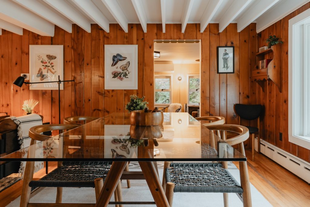 a dining room with wood paneling and a glass table