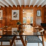 a dining room with wood paneling and a glass table